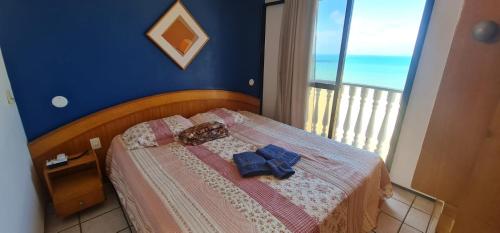Un dormitorio con una cama con paredes azules y una ventana en CLASSIC FLAT RESIDENCE Beira Mar- 1004, en Fortaleza