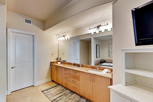 La salle de bains est pourvue d'un lavabo et d'un grand miroir. dans l'établissement Turquoise Place #2205C, à Orange Beach