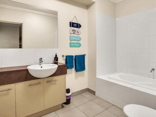 a bathroom with a sink and a tub and a toilet at Starfish Sands in Cowes