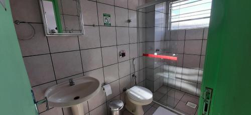 a small bathroom with a sink and a toilet at Pousada Milani in Florianópolis
