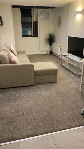 ein Wohnzimmer mit einem Sofa und einem Flachbild-TV in der Unterkunft DealHouse F7- Apartments in Huddersfield