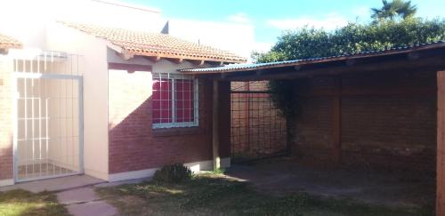een zijdelings uitzicht op een huis met een hek bij Casa dos dormitorios en excelente ubicación in San Rafael