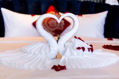 two swans making a heart on a bed at DIAMOND HOTEL VÂN ĐỒN in Cẩm Phả