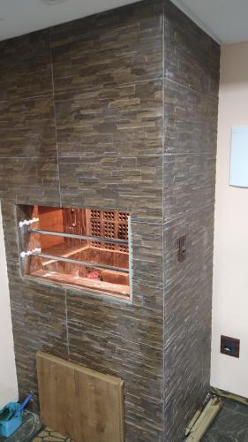 a stone wall with a fireplace in a room at Apartamento de Cobertura frente para o mar Itapema in Itapema