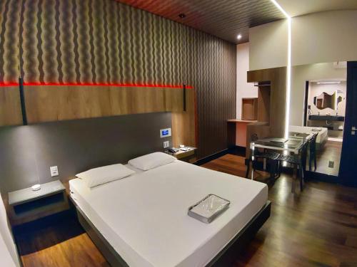 a bedroom with a bed and a table in it at Motel Dallas in Belo Horizonte