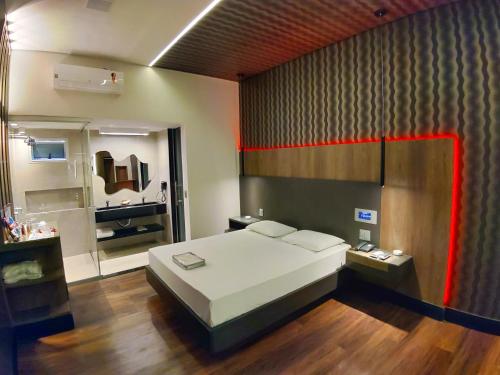 a bedroom with a large bed and a bathroom at Motel Dallas in Belo Horizonte