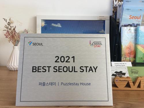 a sign for a best seoul stay on a table at Puzzlestay House in Seoul