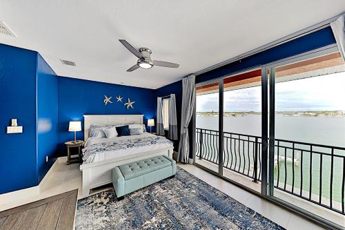 a blue bedroom with a bed and a balcony at Emerald Dreams in St Pete Beach