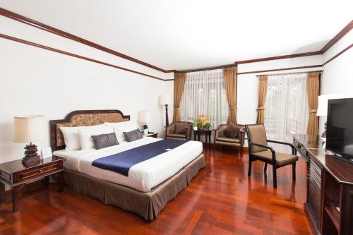 a hotel room with a bed and a television at Felix River Kwai Resort - SHA Plus,Certified in Kanchanaburi