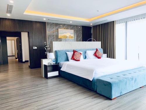 a large bedroom with a large bed with blue and red pillows at DIAMOND HOTEL VÂN ĐỒN in Cẩm Phả