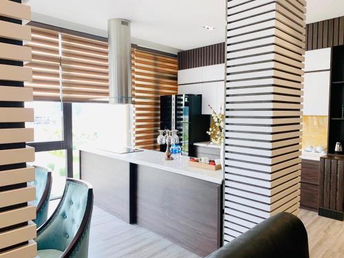 a kitchen with a counter and chairs in a room at DIAMOND HOTEL VÂN ĐỒN in Cẩm Phả