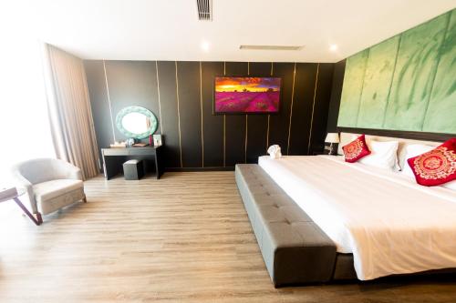 a bedroom with a large bed and a chair at DIAMOND HOTEL VÂN ĐỒN in Cẩm Phả