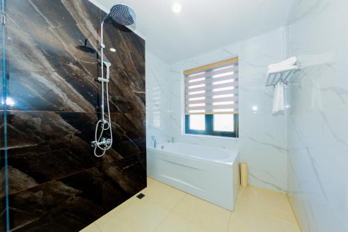 a bathroom with a shower and a bath tub at DIAMOND HOTEL VÂN ĐỒN in Cẩm Phả