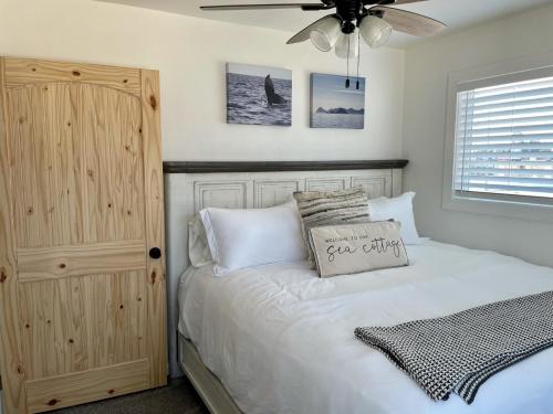 Seafarer Suites في هومر: غرفة نوم بسرير ومروحة سقف