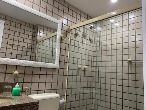 a bathroom with a shower and a toilet and a mirror at APARTAMENTO PORTO REAL RESORT VISTA ESPETACULAR in Mangaratiba