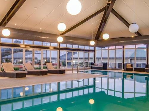 a swimming pool in a building with windows at Horizons 216 - Deluxe Lake Front Studio l Pool l Tennis l Air-Con in Jindabyne