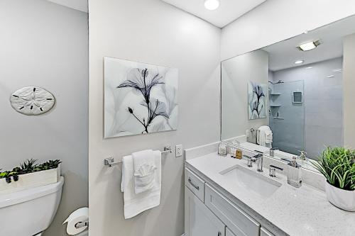 ein weißes Badezimmer mit einem Waschbecken und einem Spiegel in der Unterkunft Holiday Island 44D in Tierra Verde