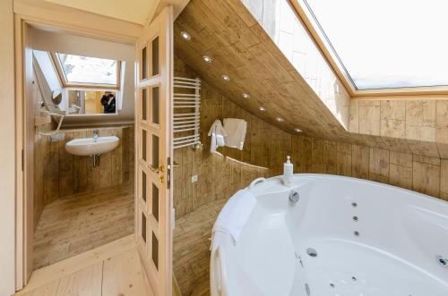 a bathroom with a white tub and a sink at Hata Hutsula in Mykulychyn