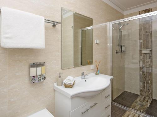 a bathroom with a white sink and a shower at Kickenback Lodge - 3BR Lodge l Gym l Indoor Pool l Tennis l WiFi l Air-Con in Crackenback