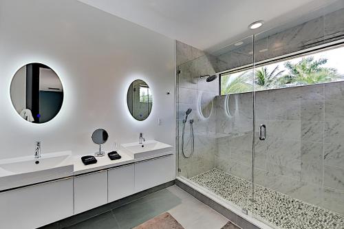 ein Bad mit einer Dusche, einem Waschbecken und einem Spiegel in der Unterkunft Wilton Manors Highlife in Fort Lauderdale