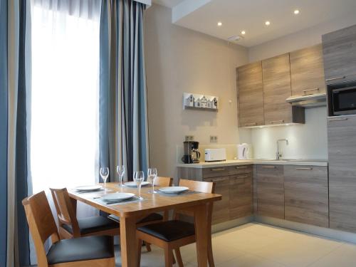 Un comedor con mesa y sillas y una cocina. en Villa des Thermes, en Saint-Malo