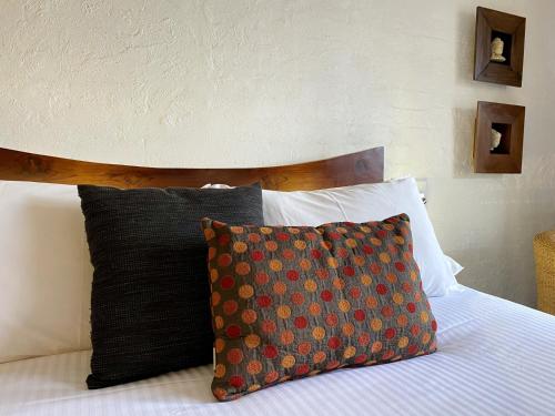 a bed with a wooden headboard and a pillow on it at Bay Breeze Boutique Accommodation in Batemans Bay