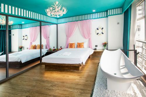a bedroom with two beds and a chandelier at EROS HOTEL 2 - Love Hotel in Ho Chi Minh City