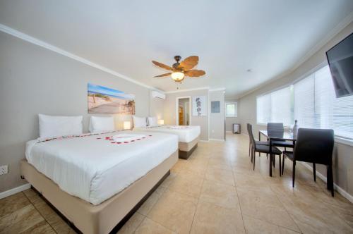 Habitación de hotel con 2 camas y mesa de comedor en Surf & Sand Hotel en Pompano Beach