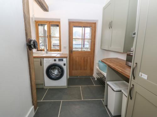 a kitchen with a washing machine and a washer at Peniarth Ganol in Tywyn