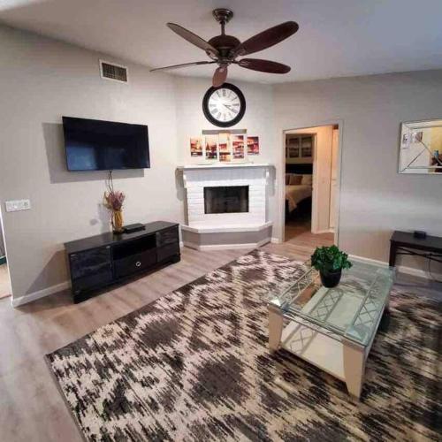 a living room with a fireplace and a clock on the wall at Lake Havasu Retreat w pool Everything Nearby! in Lake Havasu City