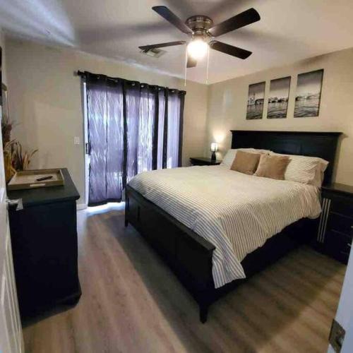 a bedroom with a large bed with a ceiling fan at Lake Havasu Retreat w pool Everything Nearby! in Lake Havasu City