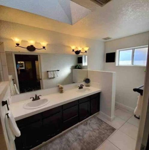 a bathroom with a sink and a large mirror at Lake Havasu Retreat w pool Everything Nearby! in Lake Havasu City