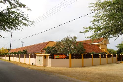 a long white fence in front of a house at Camacuri Apartments in Oranjestad