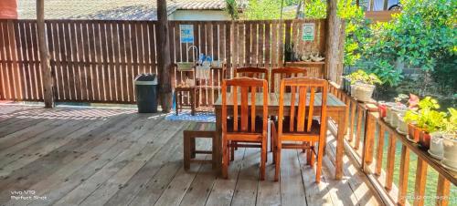a wooden deck with three chairs and a table at TA YAI HOMESTAY (ตา ยาย โฮมสเตย์) in Ko Kood