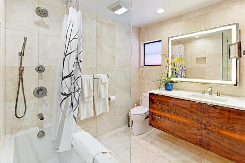 e bagno con vasca, servizi igienici e lavandino. di Breezy Ocean Escape a Lake Worth