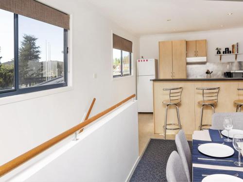 a kitchen and living room with a table and chairs at Silvertrees 5 - Central 3BR Townhouse l Lake Views l Spa l BBQ l WiFi in Jindabyne