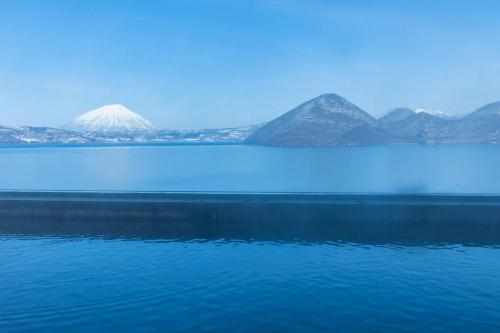 
a large body of water with mountains at Toya Kohan Tei in Lake Toya
