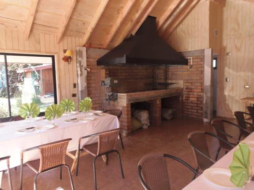 a dining room with a table and a fireplace at Hotel Departamentos del Sur in Puerto Montt