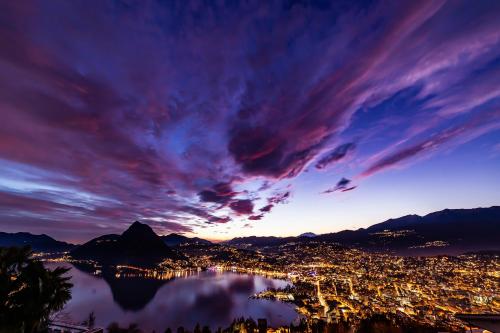 a view of a city and a lake at night at Boutique Apartments in Lugano
