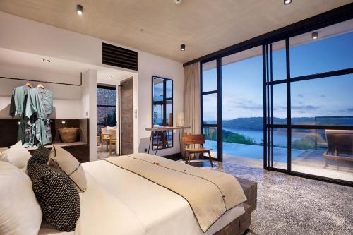 a bedroom with a large bed and a view of the water at MAUA Nusa Penida Bali in Nusa Penida