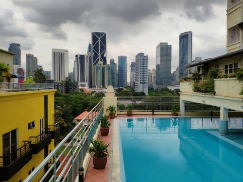 einen Pool mit einer Skyline der Stadt im Hintergrund in der Unterkunft Eco One Bedroom Apartment @ Jalan Ampang, 3 pax in Kuala Lumpur