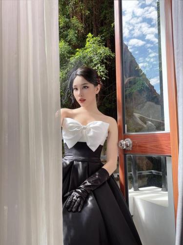 a woman in a black dress sitting in a window at Opera House Suites in Hanoi