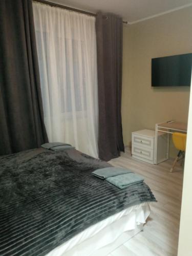 a bedroom with a bed with a window and a desk at Hotel Osher in Bukovel