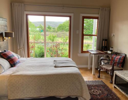 a bedroom with a bed and a large window at Doorways in Barrydale