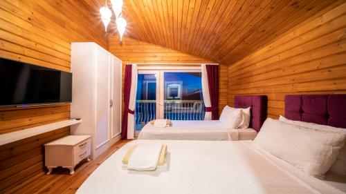 a bedroom with two beds and a television in a room at Eco villa Karanfil in Kalkan