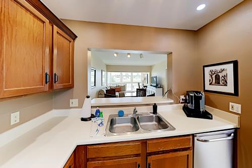 a kitchen with a sink and a mirror at BeauMer 102B in Naples