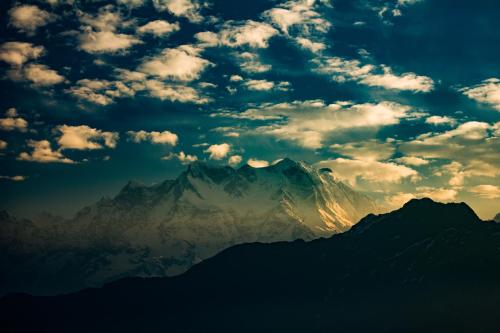 a view of a mountain under a cloudy sky at Captains Paradise Luxury Resort at Mukteshwar Hill Station in Mukteswar