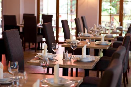 a row of wooden tables with wine glasses and napkins at Wy & Spa in Pobierowo