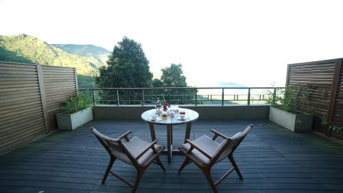 a patio with a table and chairs on a balcony at Taj Chia Kutir Resort & Spa Darjeeling in Darjeeling