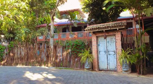 a brick house with a fence and a blue door at Celestial Inn in Mirissa
